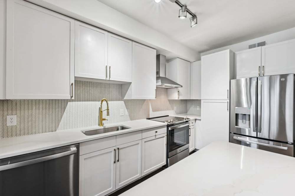 Stainless-steel appliances and white cabinetry in the kitchen at Dorian and Encore in Plano, Texas