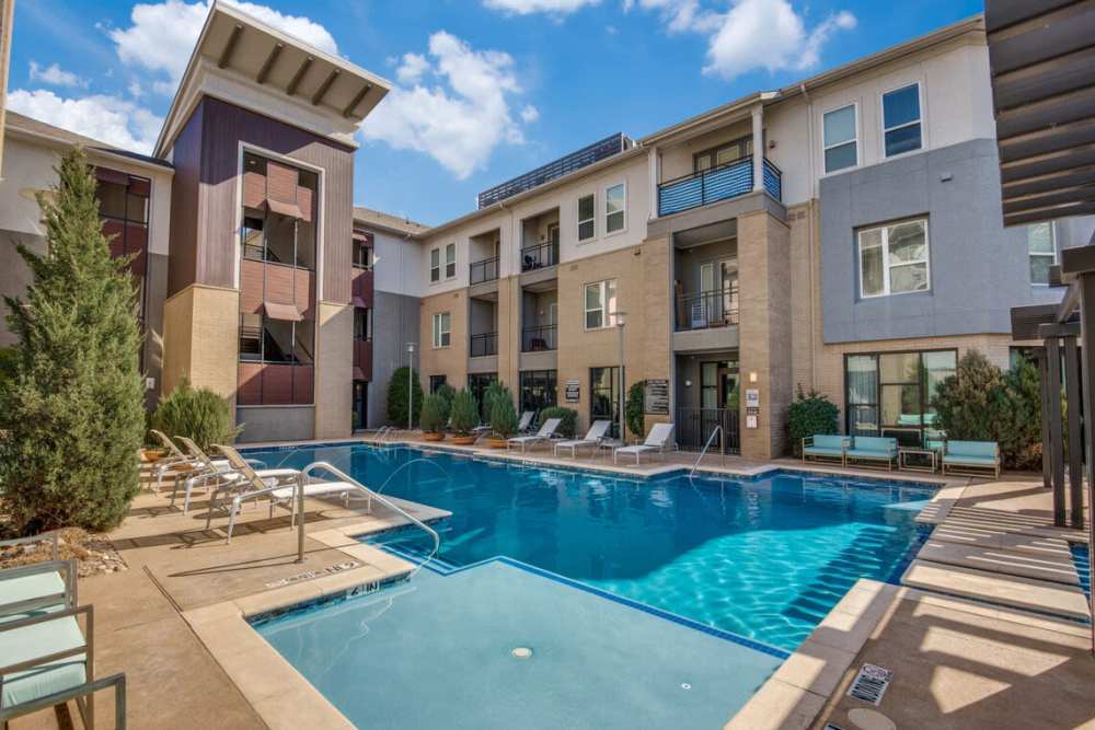 Relaxing lounge chairs beside the pool at Dorian and Encore in Plano, Texas