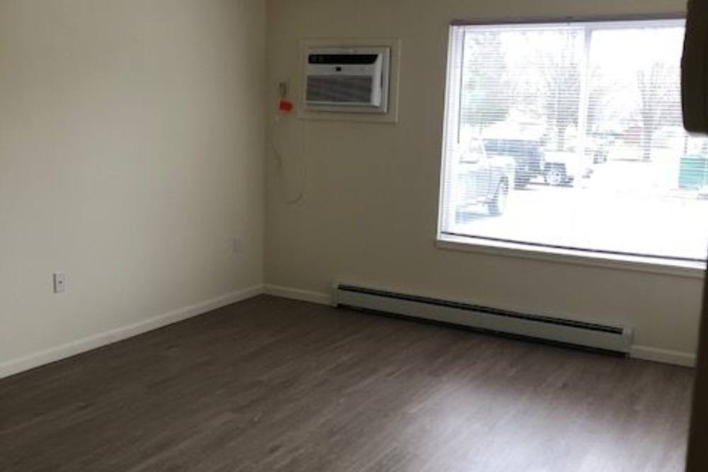 Model living space with large window at Franklin Pointe in Reed City,