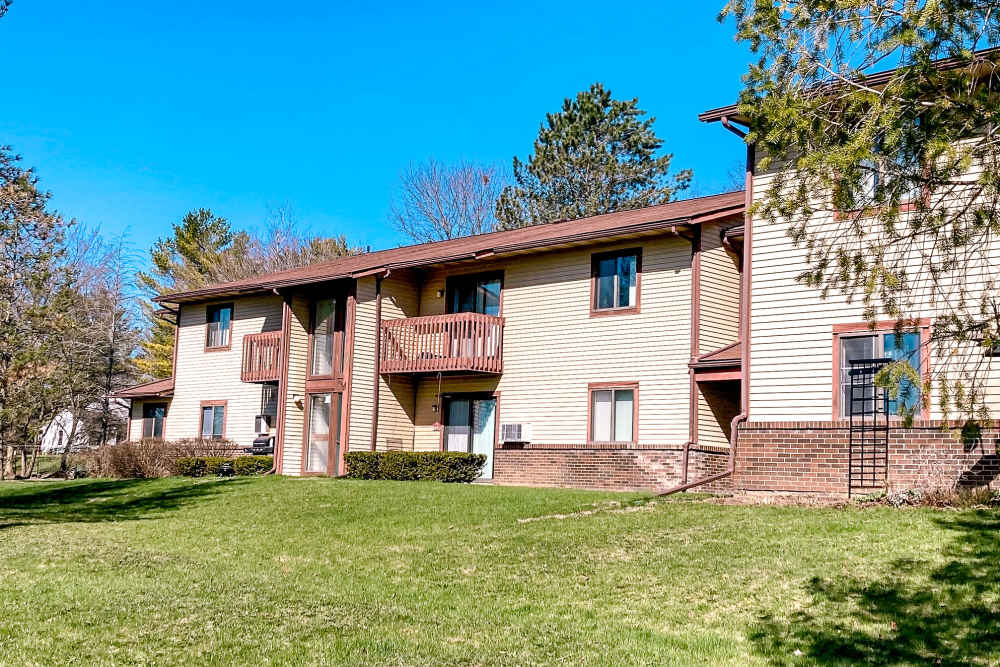 Exterior view of the apartment building with a private balcony and stairs leading to first floor at Manchester Apartments in Manchester, Michigan