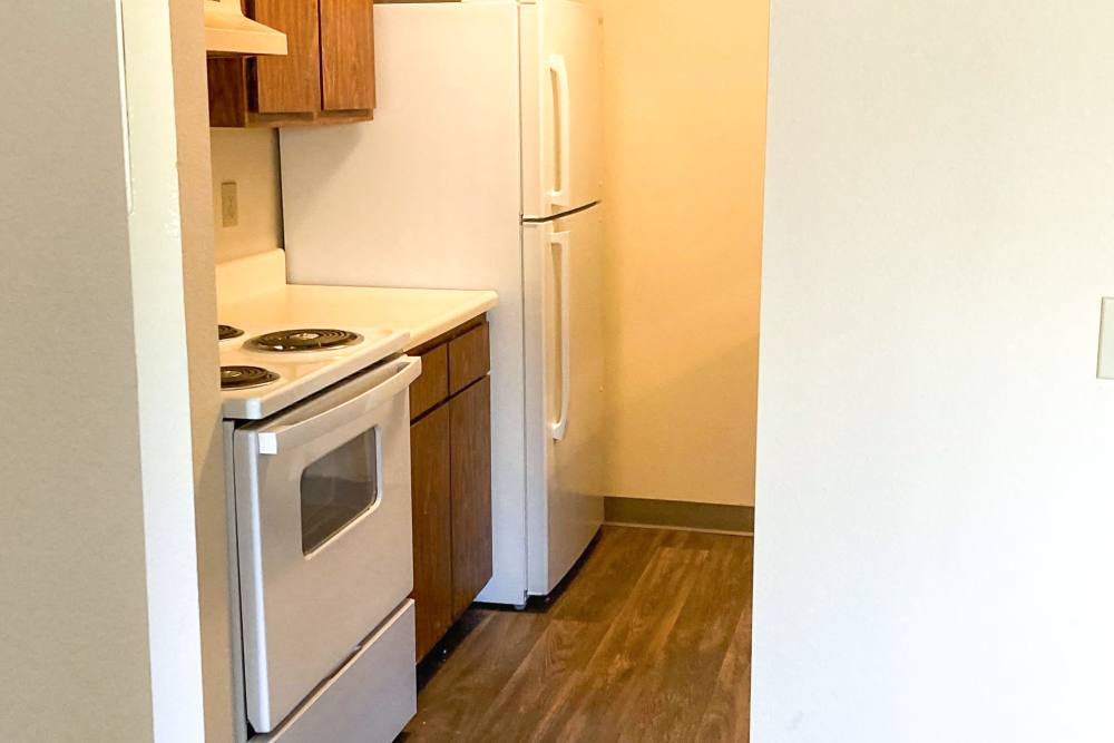Kitchen with oven and refrigerator at Manchester Apartments in Manchester, Michigan