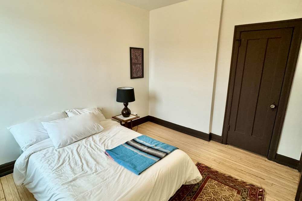 Bedroom with hard-wood style flooring at Detroit Living in Detroit, Michigan