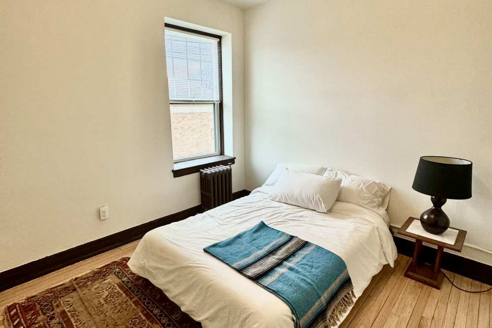 Bedroom with nightstand at Detroit Living in Detroit, Michigan