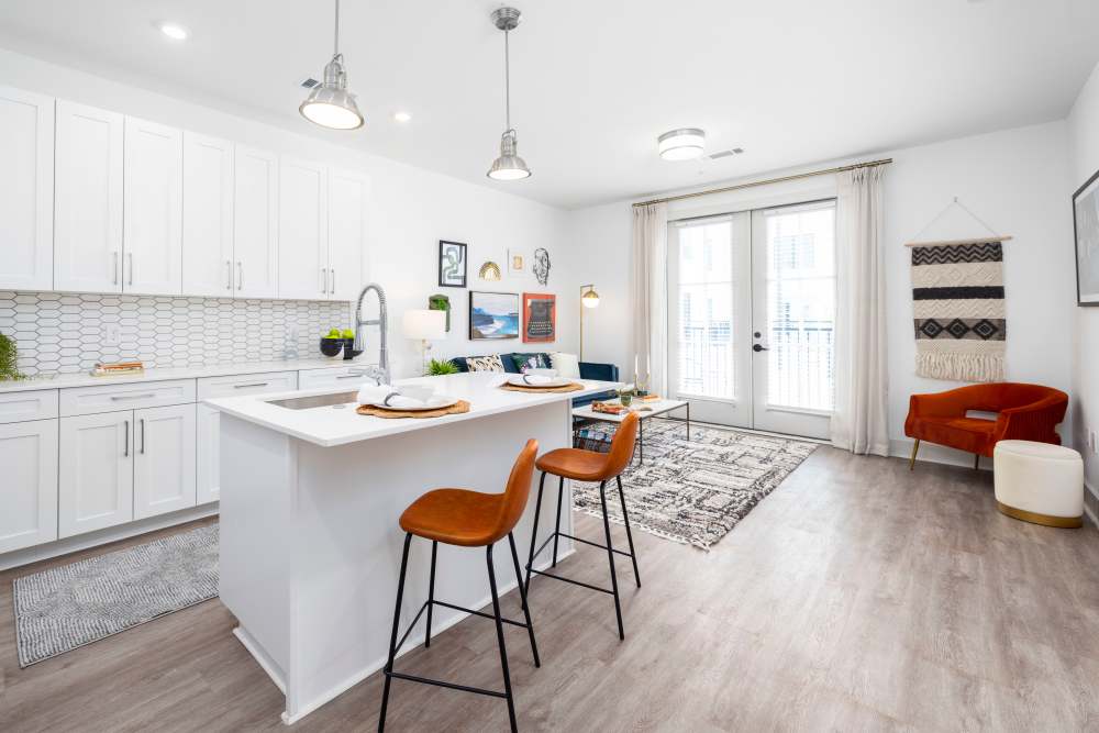 An apartment kitchen with bar seating at the island at The Lowe in Savannah, Georgia