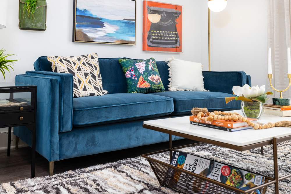 A blue couch and coffee table in an apartment living room at The Lowe in Savannah, Georgia