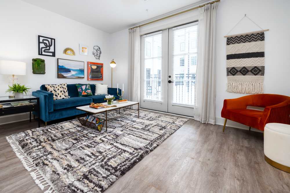 Living room with large balcony doors and hardwood floors in a model home at The Lowe in Savannah, Georgia
