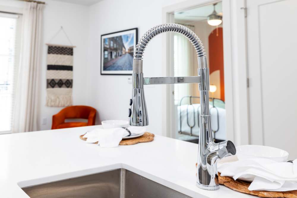 A stainless-steel faucet in the island of an apartment kitchen at The Lowe in Savannah, Georgia