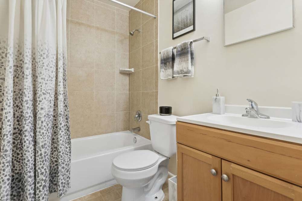 Bright bathroom with wooden vanity unit at Smallwood Gardens in Waldorf,Maryland