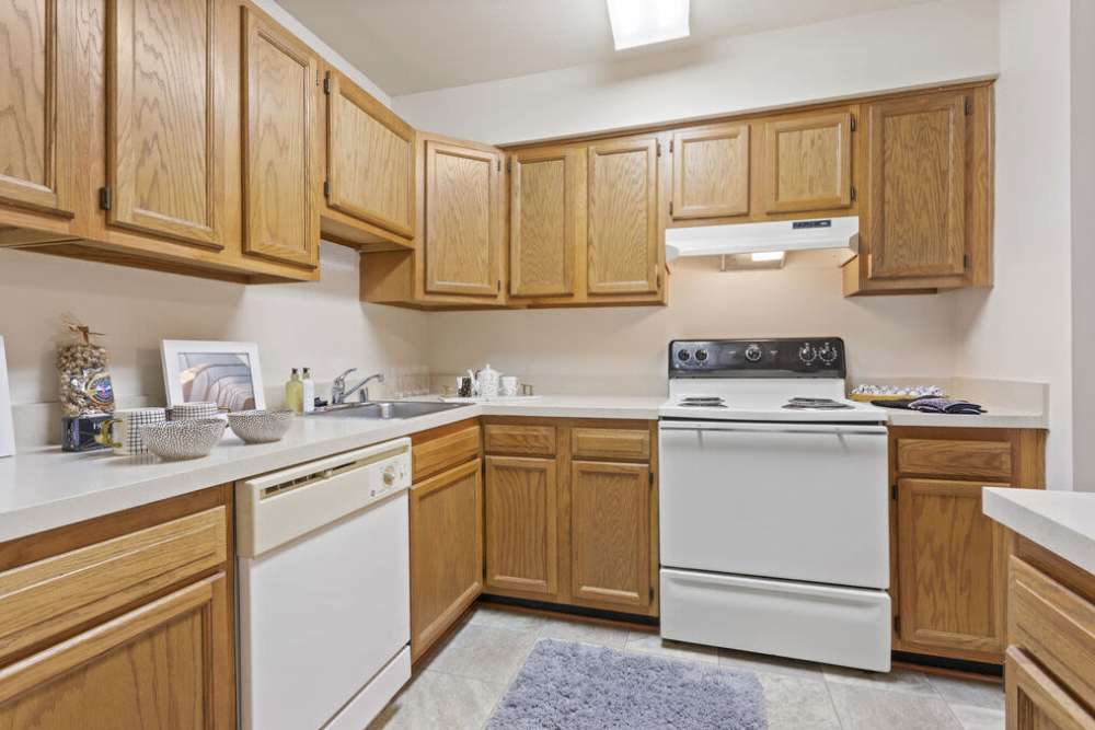 Apartment kitchen with wooden cabinetry at Smallwood Gardens in Waldorf,Maryland