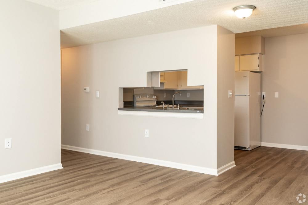 Unfurnished living room with view to kitchen at West Village Apartments in Hillsborough, North Carolina