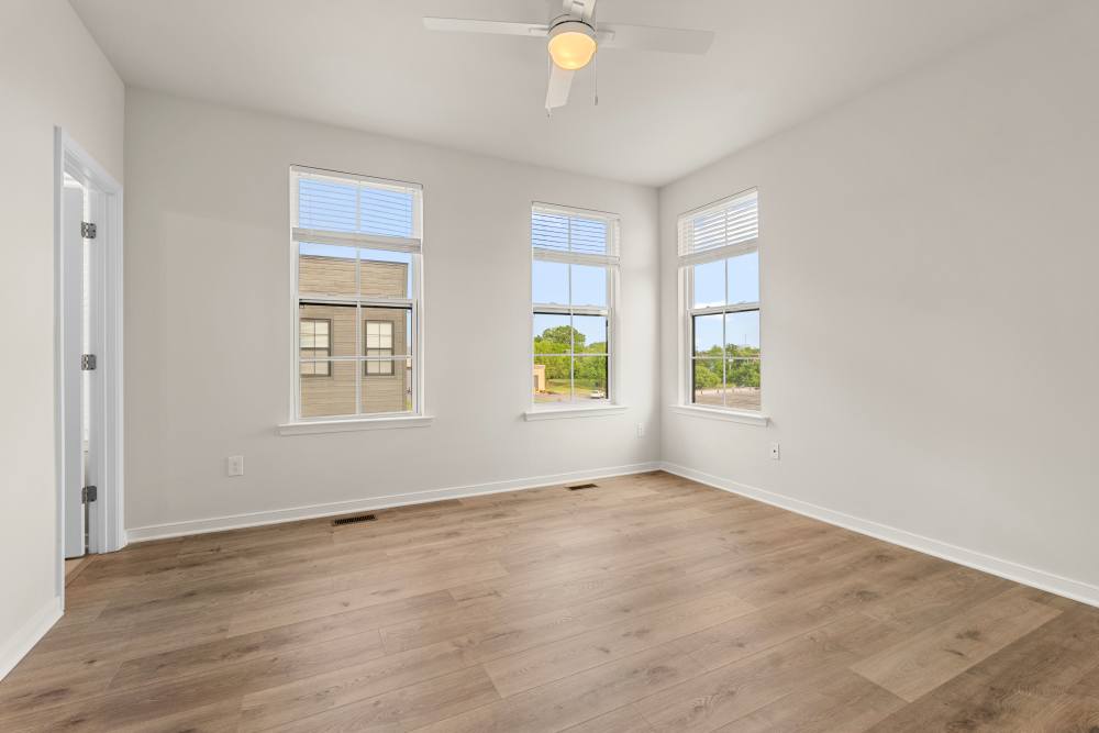 Bedroom with ceiling fan and large windows at The Westbrook at Brewer's Row in Richmond, Virginia