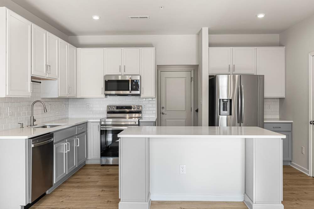 Modern kitchen with granite countertops and tile backsplash at The Westbrook at Brewer's Row in Richmond, Virginia