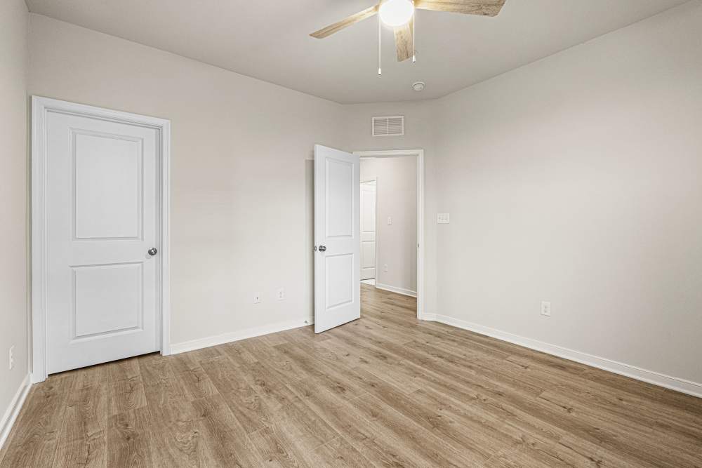 Spacious bedroom with plank flooring and closet at The Westbrook at Brewer's Row in Richmond, Virginia