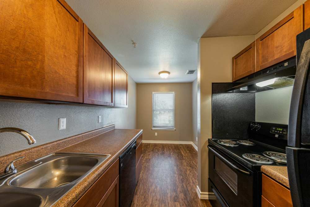 Modern kitchen with wooden cabinets at Palatia Apartment Homes in San Antonio, Texas
