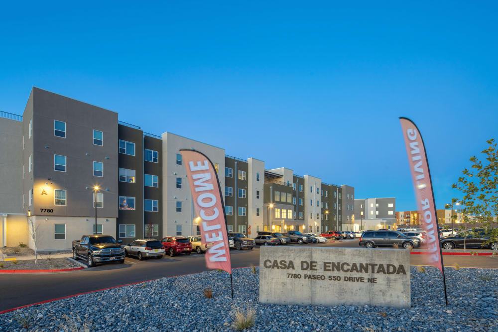 View of apartment building and welcome sign at Casa de Encantada Senior Apartments in Rio Rancho, New Mexico