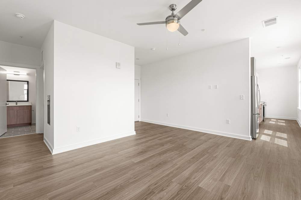Living space with ceiling fan and white-painted wall at The Alder on Dabney in Richmond, Virginia