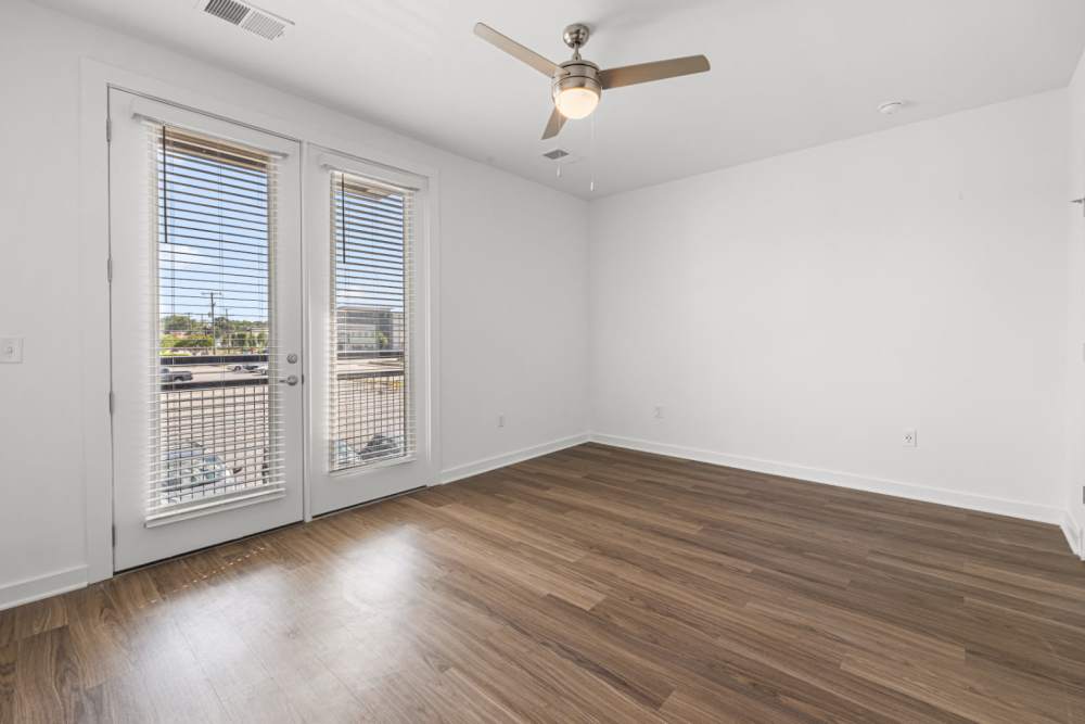 Bedroom with balcony access, window, and ceiling fan at The Alder on Dabney in Richmond, Virginia