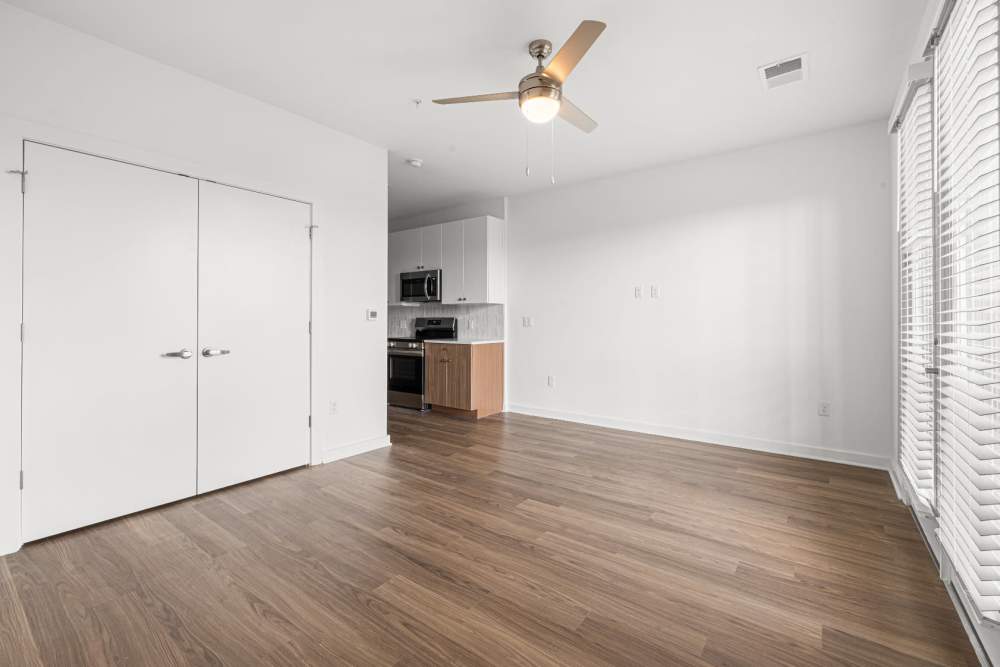 Spacious living room with wood-style floors and ceiling fan at The Alder on Dabney in Richmond, Virginia