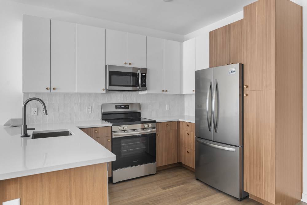 Kitchen with counter top, wooden flooring and white-painted cabinet at The Alder on Dabney in Richmond, Virginia