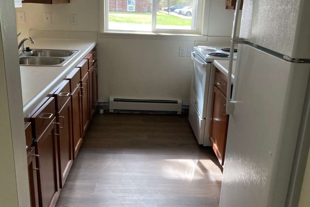 Kitchen with white color appliance at Village Apartments in Bellaire, Michigan