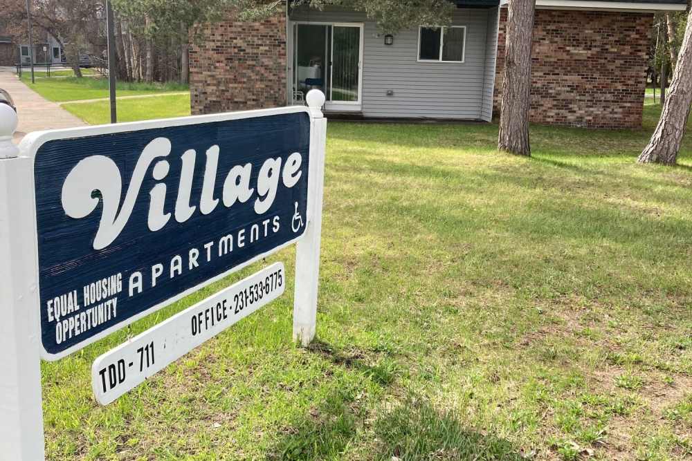 Community signage board at Village Apartments in Bellaire, Michigan