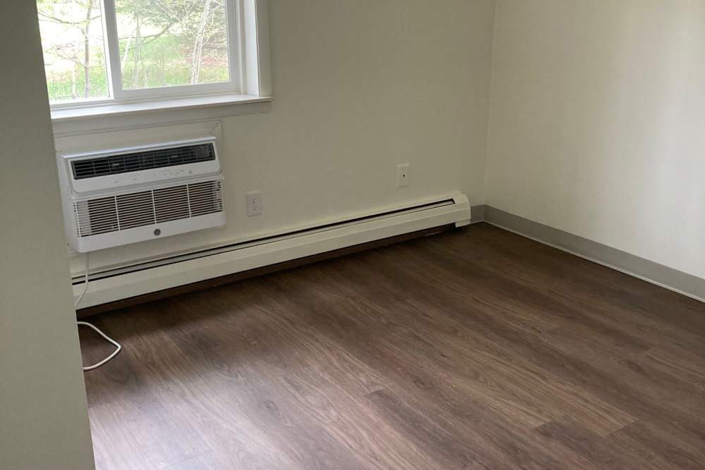 Unfurnished bedroom with window at Village Apartments in Bellaire, Michigan