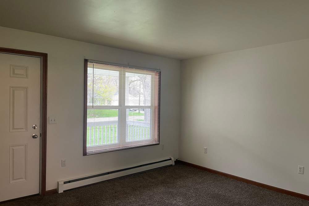 Bright living room with large windows at Trinity Buena Vista in Saint Charles, Michigan,