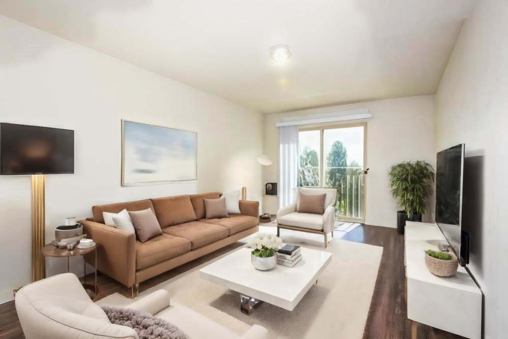 Spacious living room with a comfortable couch and a large TV at Blanton Commons in Beaverton, Oregon