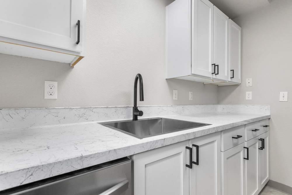 Kitchen with white cabinetry, granite countertop and sink setup at Reedville Meadows in Beaverton,Oregon