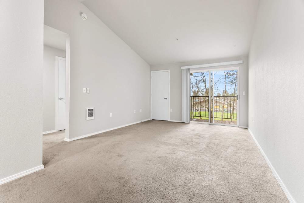 Spacious living room with carpet flooring and patio access at Reedville Meadows in Beaverton,Oregon