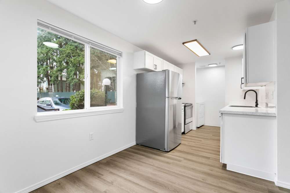 Apartment kitchen with wood-style flooring and a window at Reedville Meadows in Beaverton,Oregon