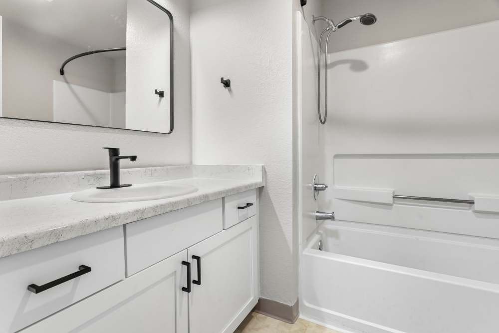 Bright bathroom with a bath tub and a large mirror at Reedville Meadows in Beaverton,Oregon
