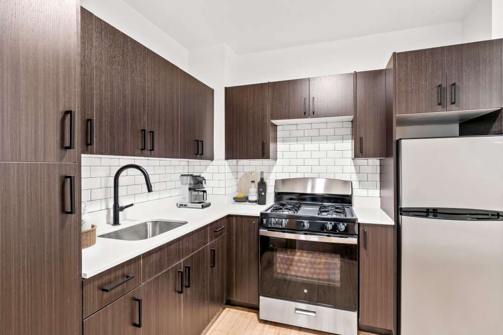 Apartment kitchen with chocolate colored cabinetry at Detroit Living in Detroit,Michigan