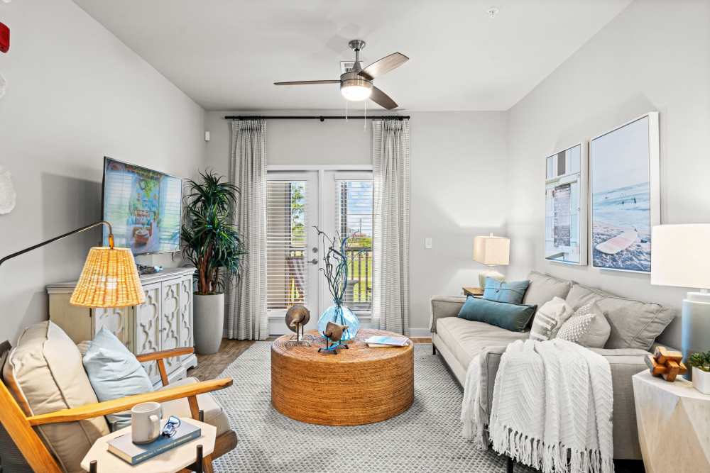 Living room with large windows, couch, and coffee table at Mexico Beach Crossings in Mexico Beach, Florida