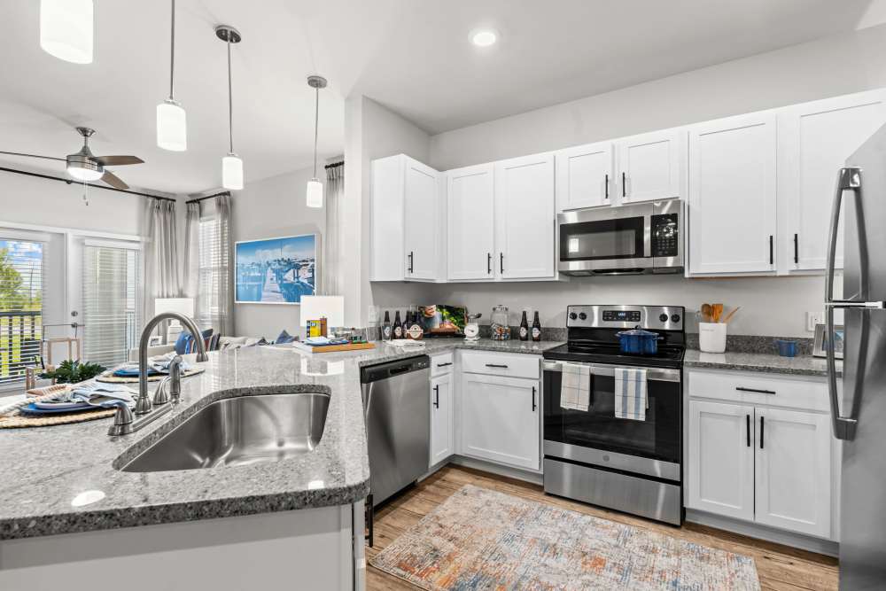 Apartment kitchen with a waterfall sink, granite countertops and stainless-steel appliances at Mexico Beach Crossings in Mexico Beach, Florida