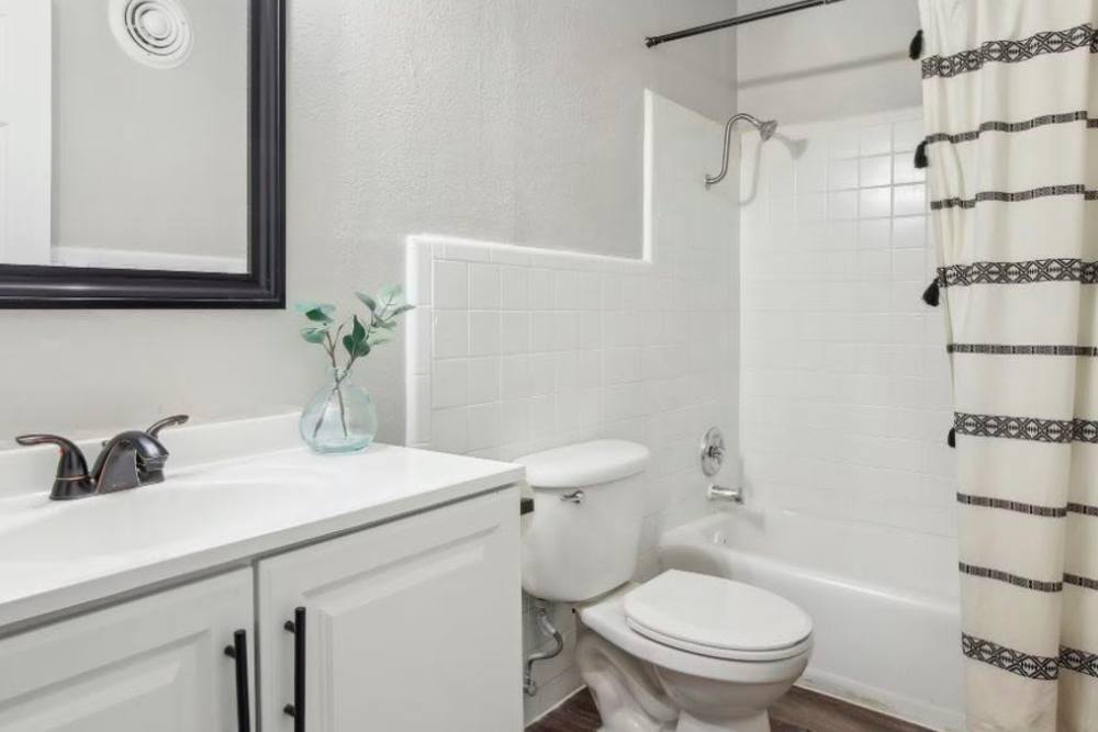 Bright bathroom with white cabinetry and vanity units at Flats On Wakefield in San Antonio,Texas