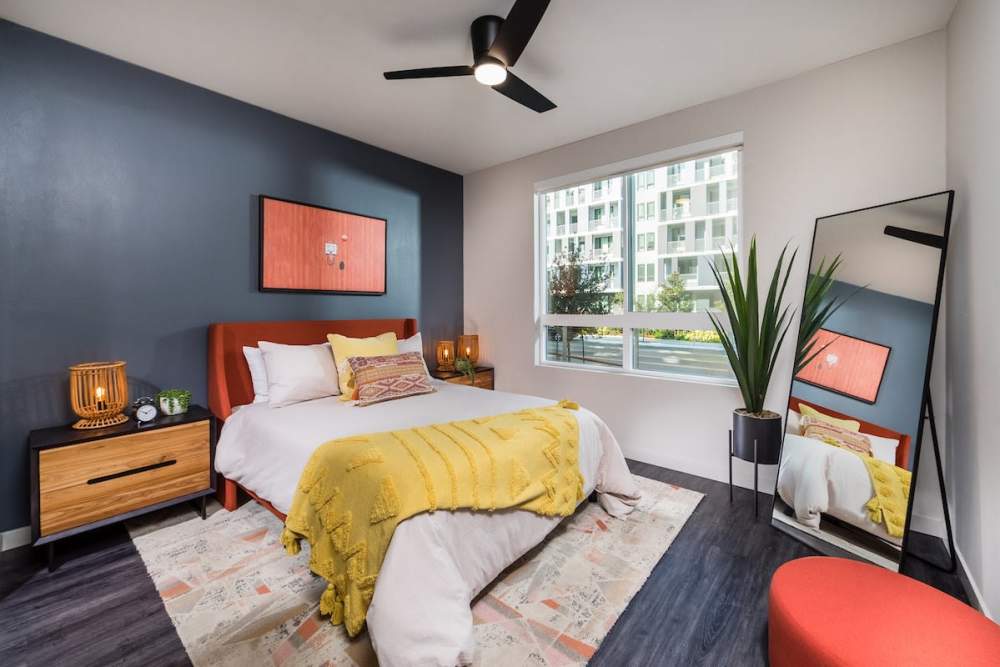 Bedroom with a ceiling fan and accent wall at The Fields in Milpitas, California