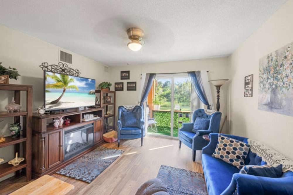 Gorgeous living room with unique blue furniture at Pelican Isles Apartments in Sebastian,Florida