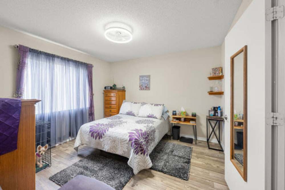 Bedroom with a large window covered with blinds at Pelican Isles Apartments in Sebastian,Florida
