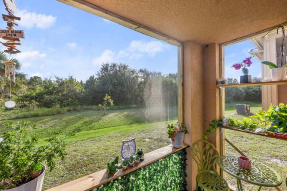 Private balcony with chairs and lawn view at Pelican Isles Apartments in Sebastian,Florida