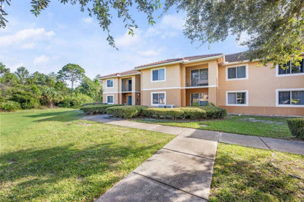Property exterior with a walkway and a lawn at Pelican Isles Apartments in Sebastian,Florida