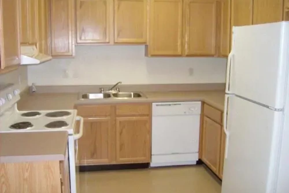Kitchen with wooden cabinets at Ochlockonee Pointe Apartments in Midway, Florida