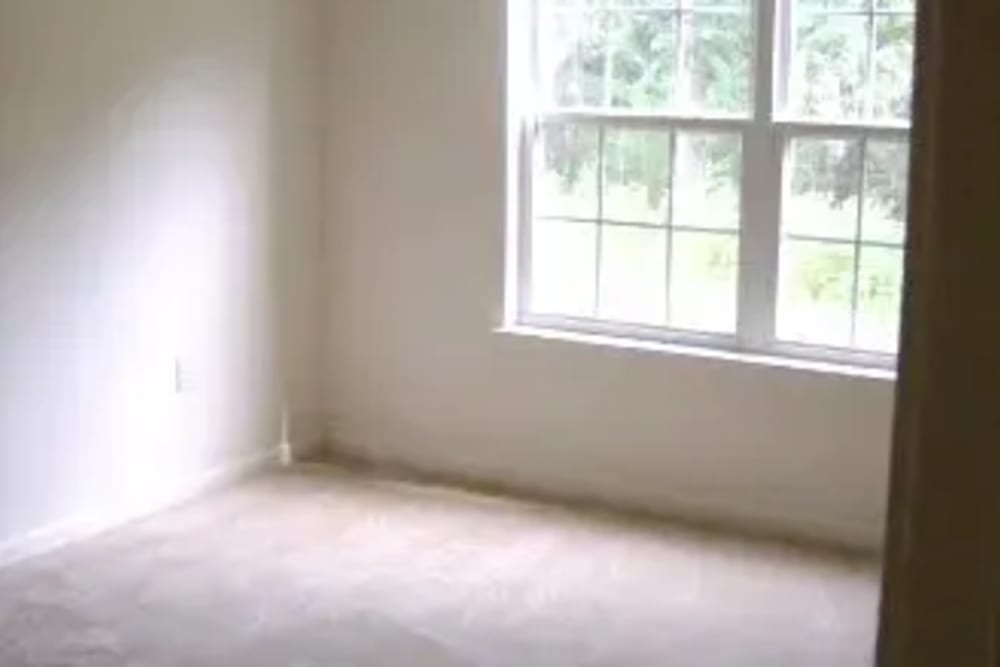 Bedroom with a large window at Ochlockonee Pointe Apartments in Midway, Florida
