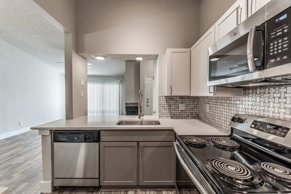 Kitchen with wooden cabinets and stainless-steel appliances at The Biltmore in The Woodlands, Texas