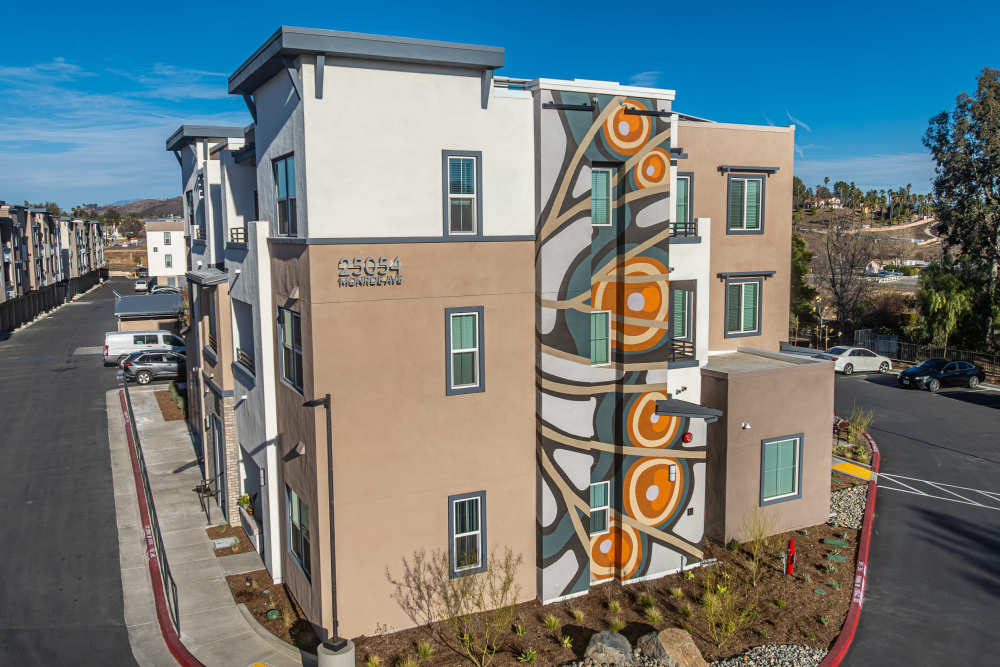 An apartment building featuring a colorful mural painted on its side at Monamos Terrace Apartments in Murrieta, California