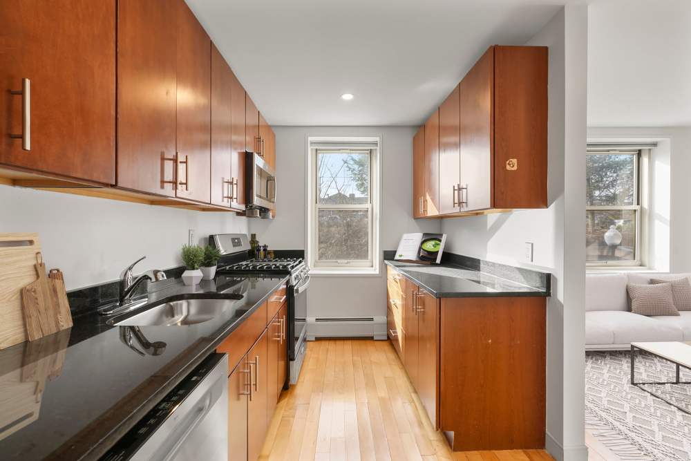 Living space with wood-style flooring in modern apartment at Camelot Court in Brighton, Massachusetts