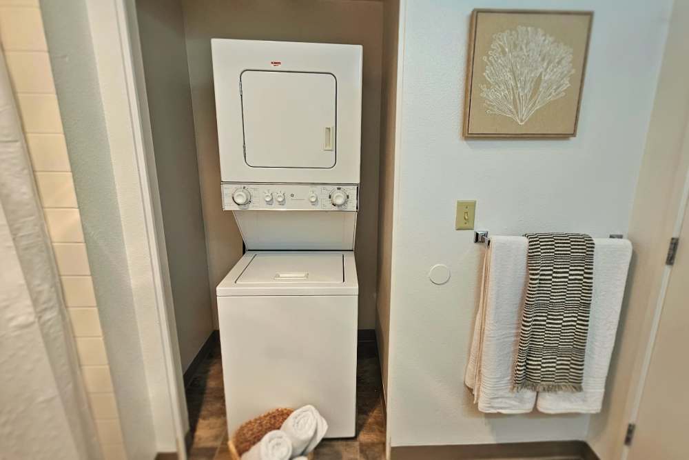 A compact washer and dryer set installed in a small bathroom, maximizing space efficiency at Neawanna By The Sea in Seaside, Oregon