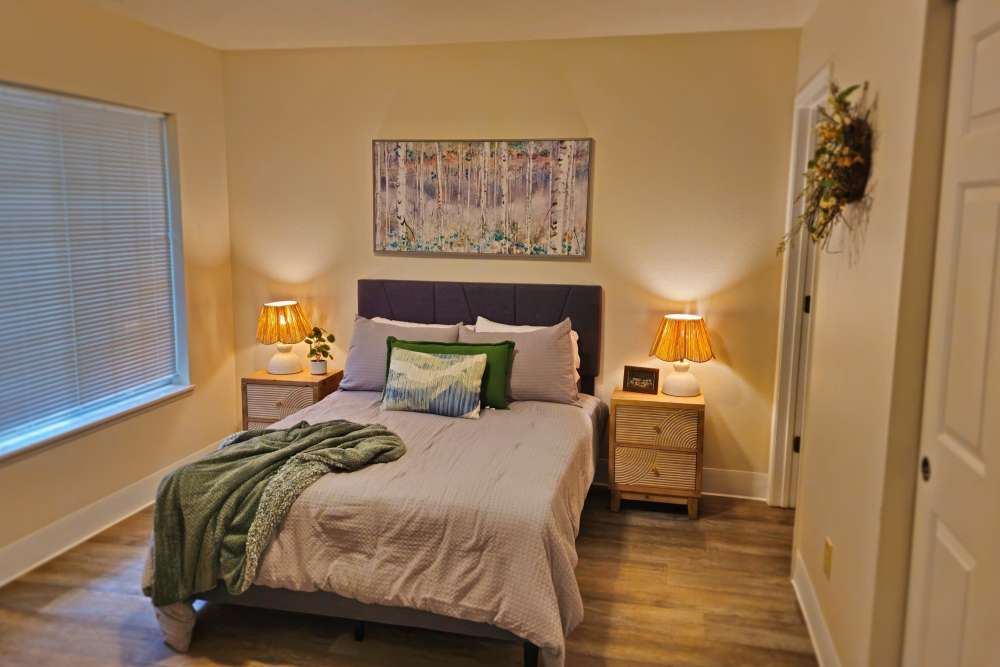 A cozy bedroom featuring a bed, two nightstands, and a window allowing natural light to enter the space at Neawanna By The Sea in Seaside, Oregon
