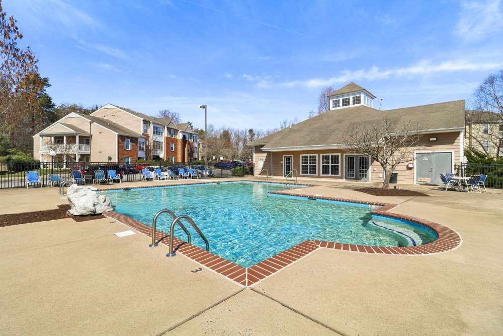 Swimming pool with lounge chair at Malvern Lakes Apartments in Fredericksburg, Virginia