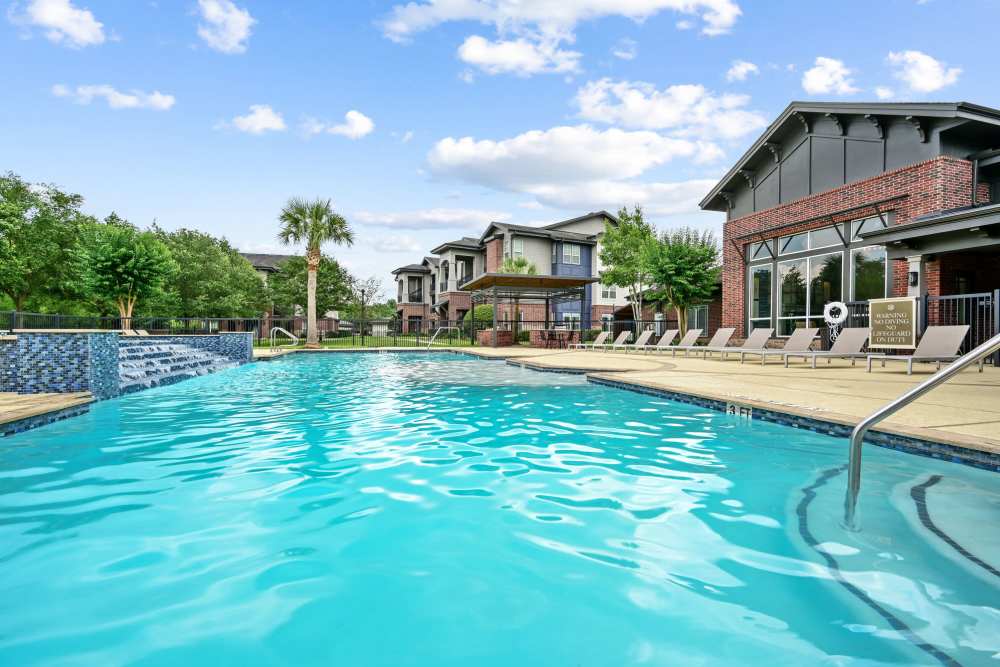 Pool with lounge beds at Beacon Lakes in Dickinson, Texas